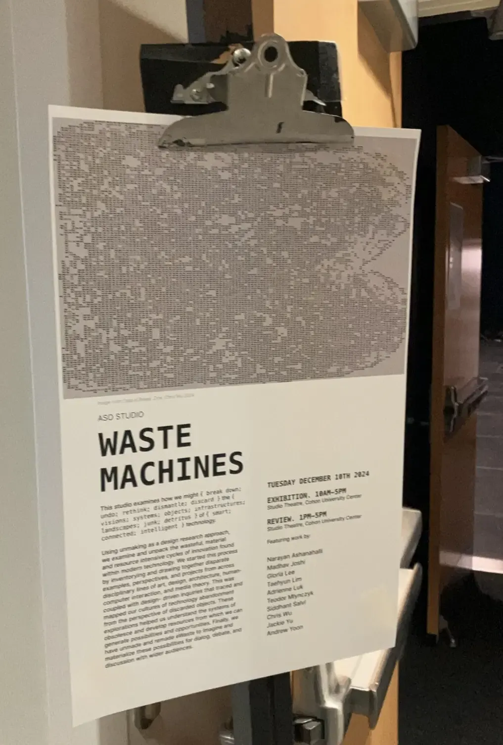 The Waste Machines exhibition poster on a clipboard