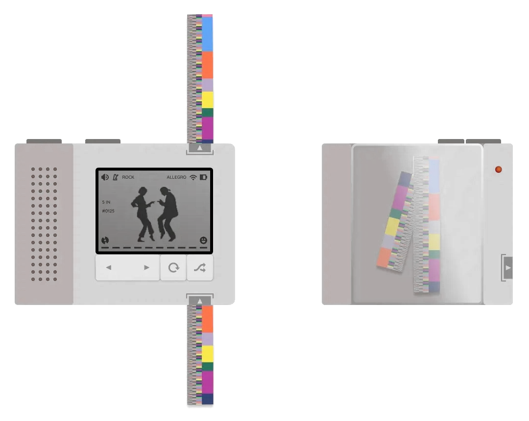 A small grey music player with a screen of two dancers, colour-coded paper strips feeding through it, beside a box of strips